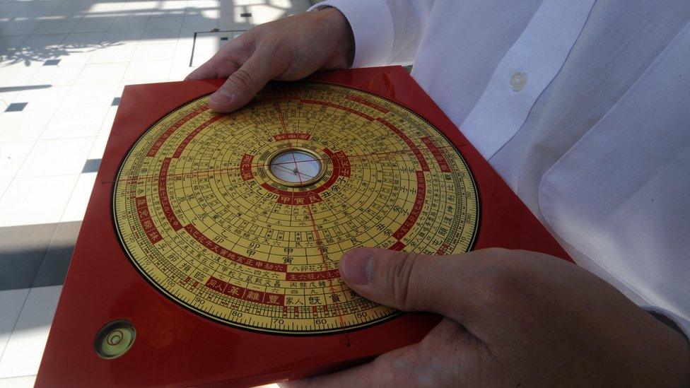 Feng Shui master Jet Li shows the reading from a compass for a building entrance in Singapore on January 21, 2009