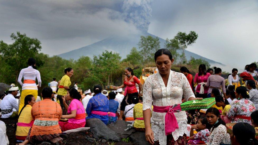 Balinese Hindus take part in a ceremony, where they pray near Mount Agung in hope of preventing a volcanic eruption, in Muntig village