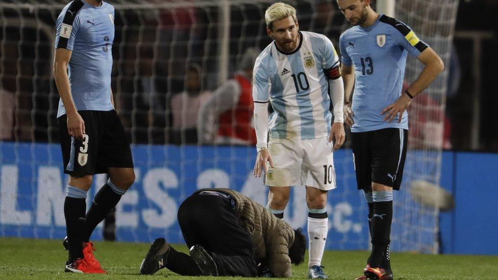 An Aregentina fan kisses the boots of Lionel Messi