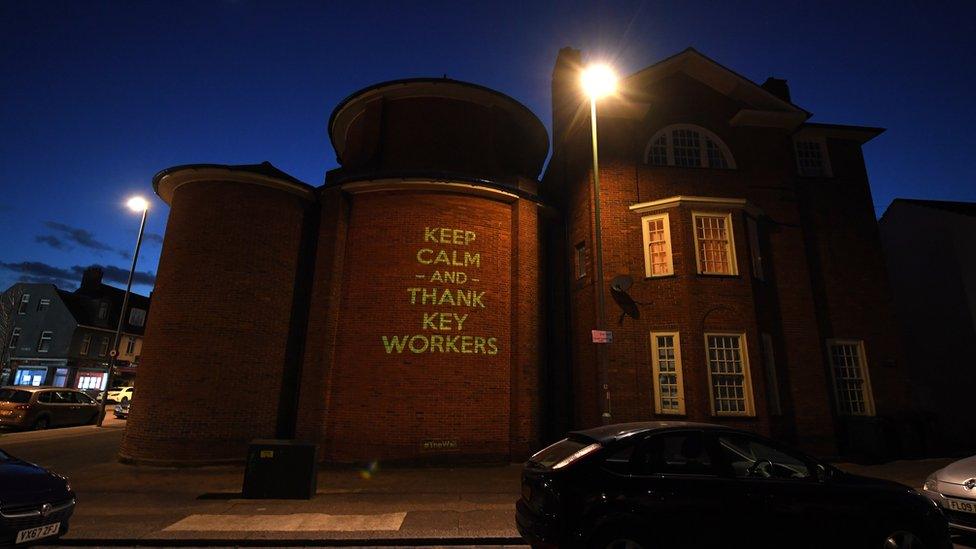 A message of 'Keep Calm And Thank Shop Workers' by Illustrator and artist Mike Dicks is projected onto a wall of a church on March 29, 2020 in Brighton & Hove, England