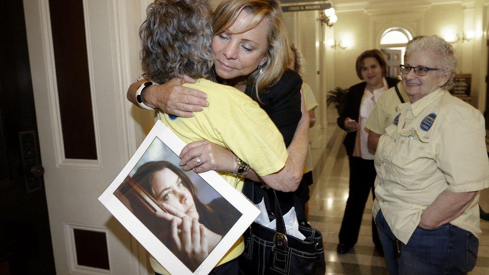 Debbie Ziegler - holding a photo of her daughter, Brittany Maynard - hugs a supporter after the measure was passed