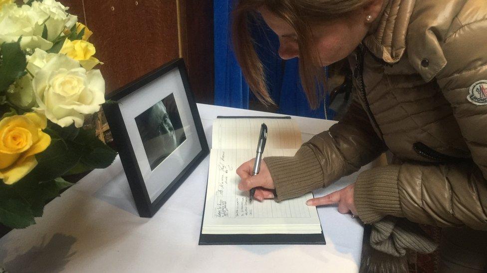 Woman signing condolence book