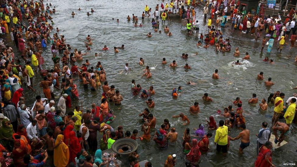 Hindu devotees pray while standing in the Godavari river during "Kumbh Mela" or the Pitcher Festival in Nashik, India, 28 August 2015