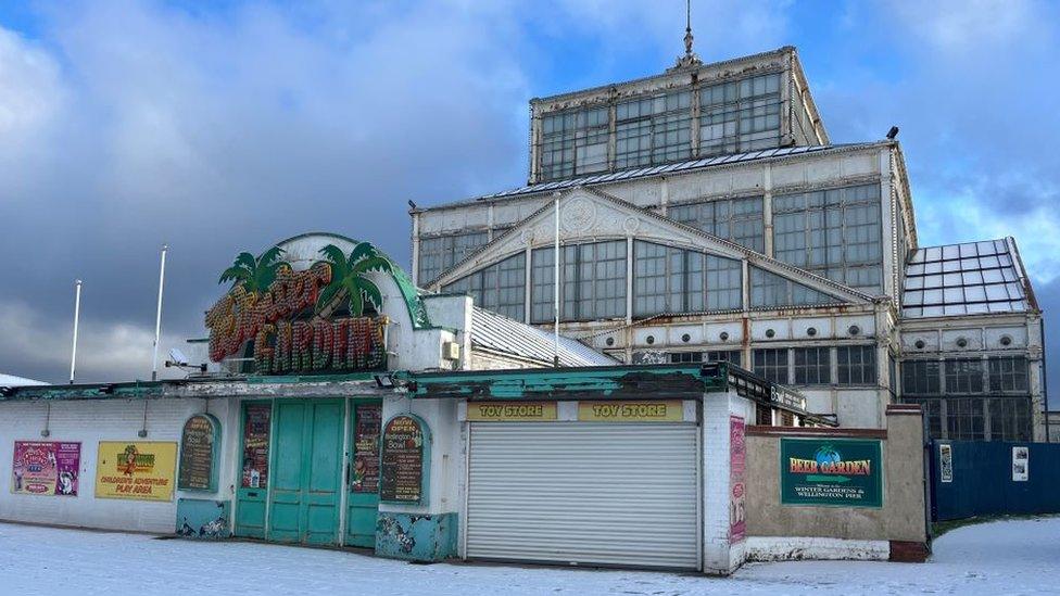 Wintere Gardens on the sea front with snow outside it.