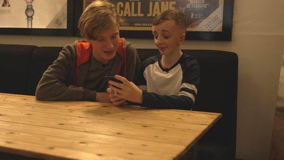 Two teenagers looking at a phone