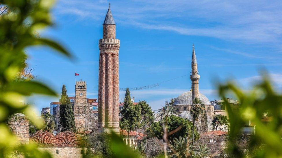 : A view of the Yivli Minaret Mosque and Kaleici clock tower located in the old town of Kaleici, one of the tourist attractions in Antalya, Turkey on March 2, 2018.