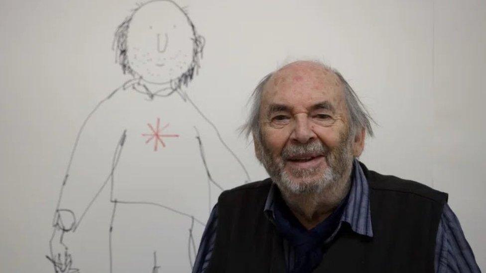 Quentin Blake smiles with an illustration of a man behind him