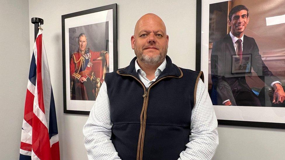 Mark Jenkinson, Conservative MP for Workington, stood between a photograph of Rishi Sunak and another of King Charles III