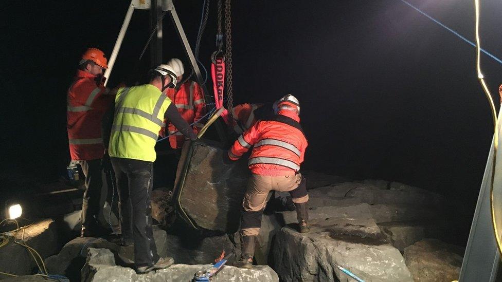 The boulder being moved