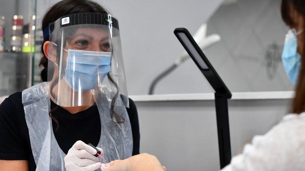 Nail technician wearing a face shield