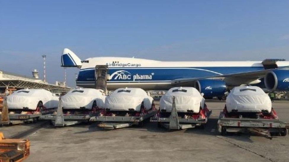 Five Maseratis seen at Port Moresby airport, draped in protective white covers