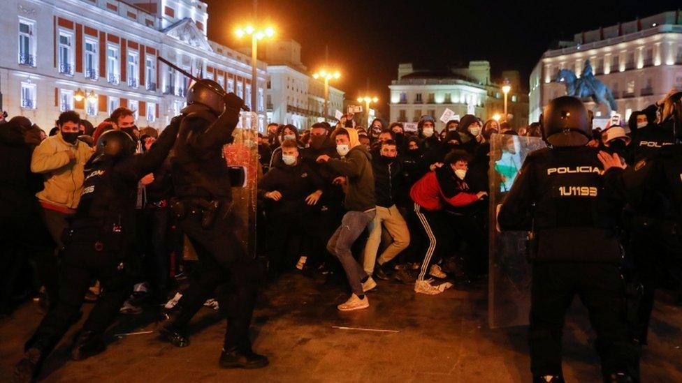 Police officers clash with demonstrators as supporters of Catalan rapper Pablo Hasél protest against his arrest in Madrid, Spain