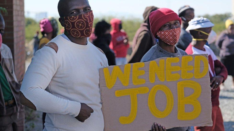 Protesters display a placard near the Seraleng mining community on May 18, 2020, in Rustenburg, South Africa.