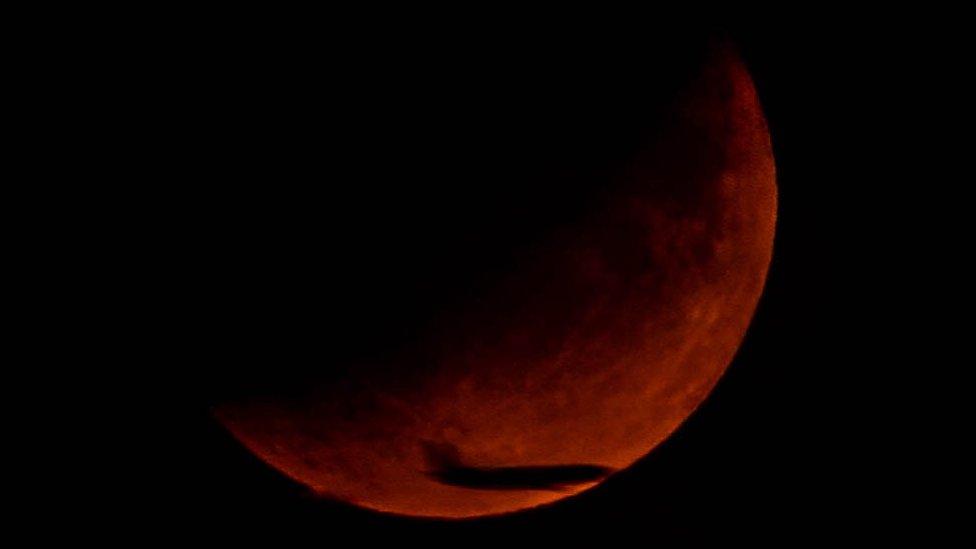 Matt Morris' image of the Moon over Bradley Stoke with a plane flying across it