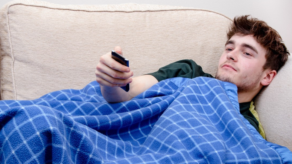 Man under a blanket on the sofa