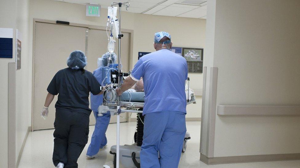 Hospital staff push a patient on a gurney