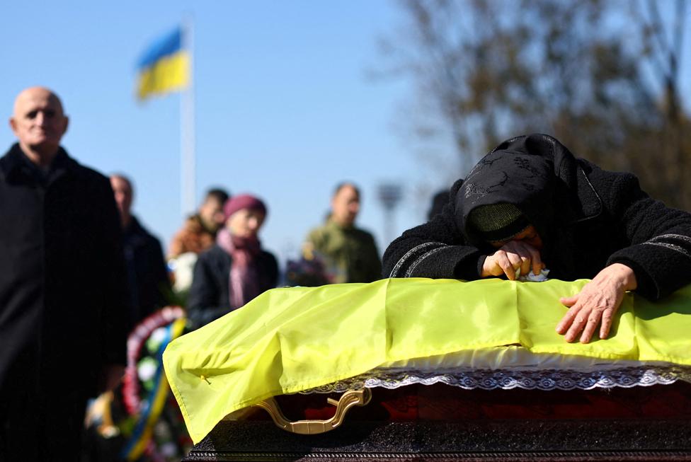 Family members and comrades of Maj Ivan Skrypnyk pay their last respects during his funeral service in Lviv, Ukraine.