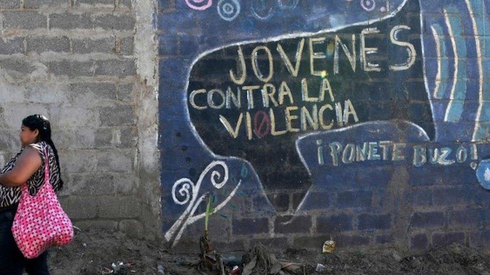 Woman next to mural in Tegucigalpa, Honduras