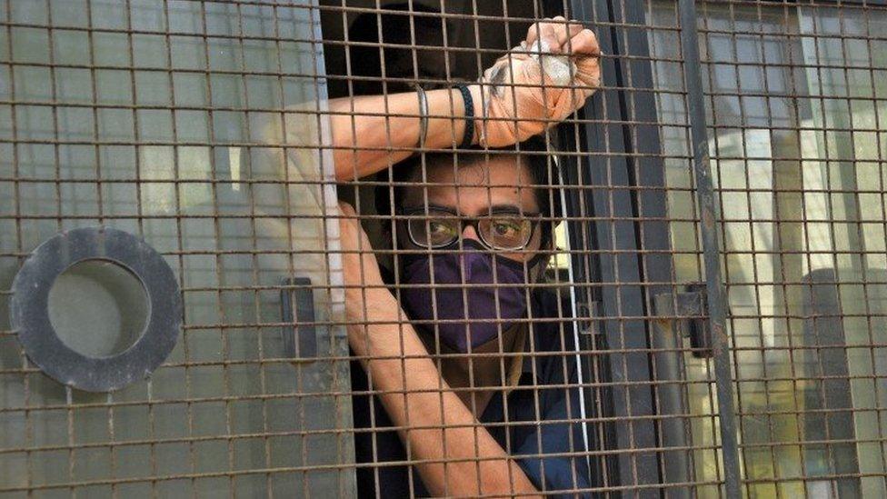 Arnab Goswami, one of India"s top TV news anchors, sits inside a police van outside a court after he was arrested, at Alibaug town in the western state of Maharashtra, India, November 4, 2020.