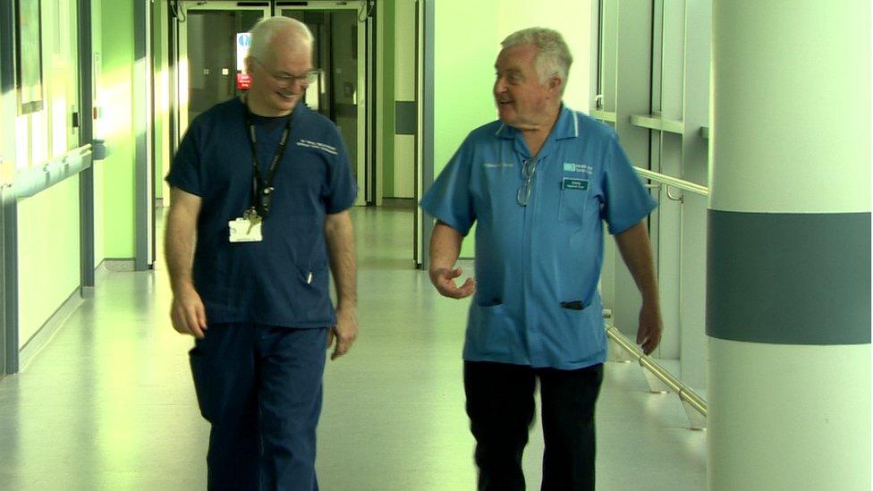 Dr Brian McCloskey and Jimmy Cooper walk along a hospital ward corridor