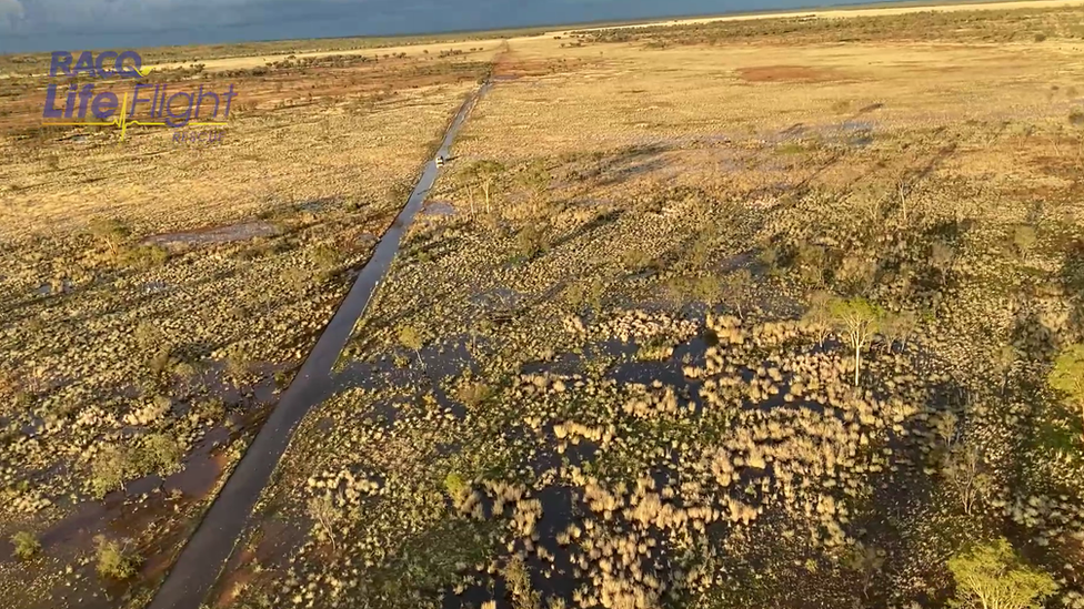 Aerial view of the stranded car on the flooded highway