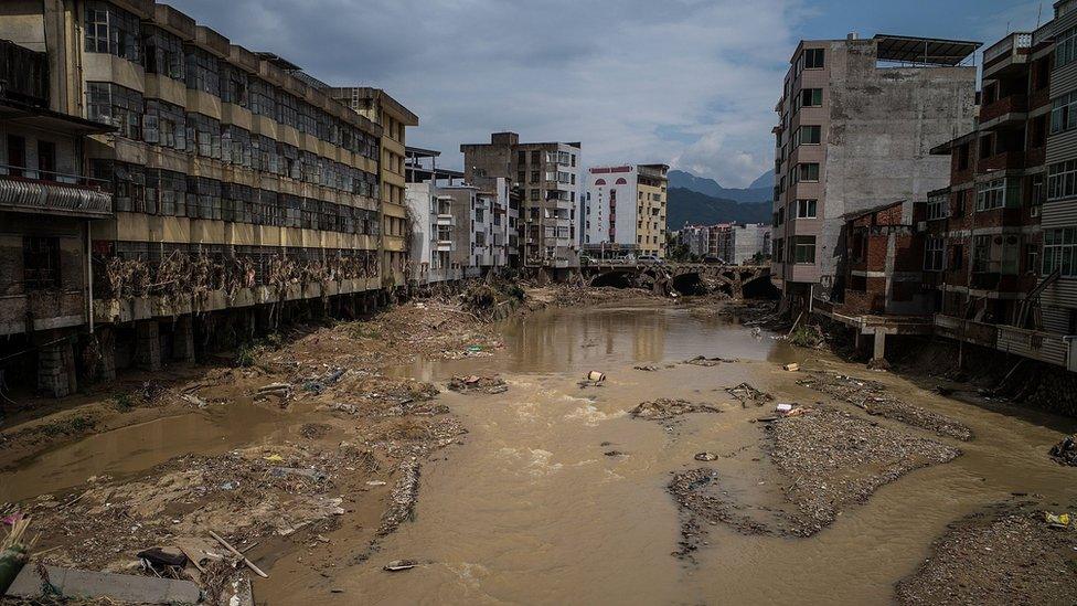 The river in Bandong Town on 12 July 2016, in Fuijan, China, showing riverside buildings damaged and a river full of debris.