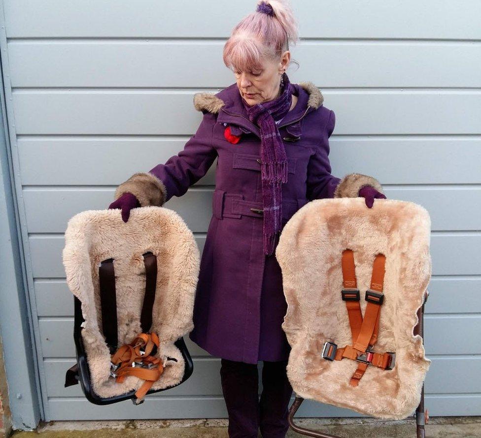 Mel Kirkpatrick holding her children's old car seats