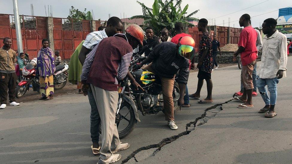 Goma residents inspect a large crack in the ground caused by aftershocks of last weekend's eruption