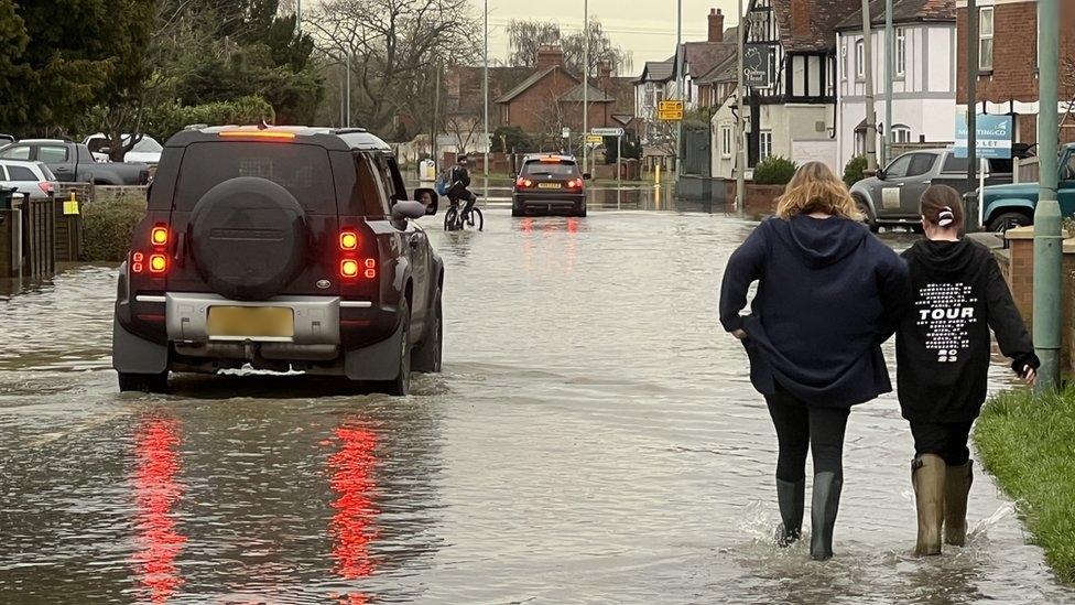 People and car on flooded road in Longford