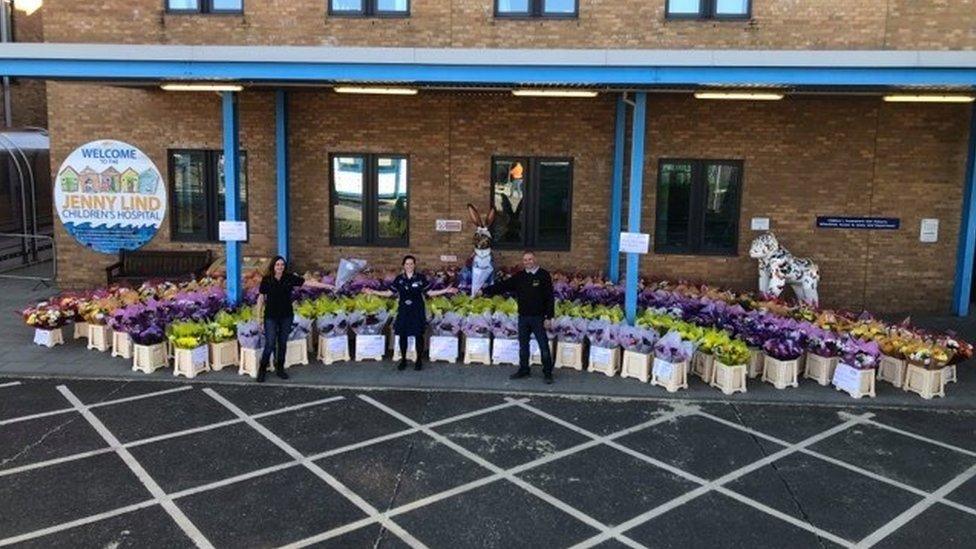 Mr and Mrs Storey donating one of the bouquets to ward sister Sammy Richie