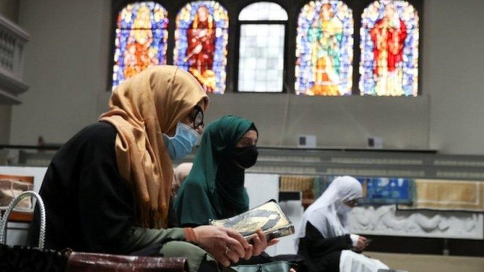 Women wearing headscarves and face masks attend Friday prayers at a Berlin church