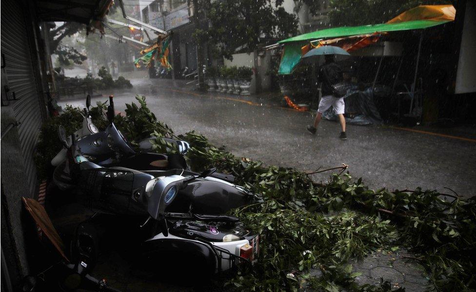 A man walks past motorcycles damaged by Typhoon Megi in Hualien, eastern Taiwan 27 September 2016.