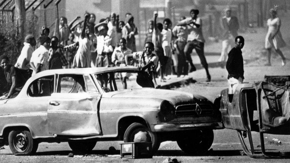 South African protestors barricade a road in Soweto using cars as roadblocks to protest against the use of Afrikaans in schools