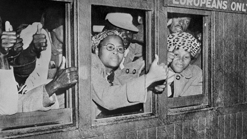 women protesting apartheid signs on busses