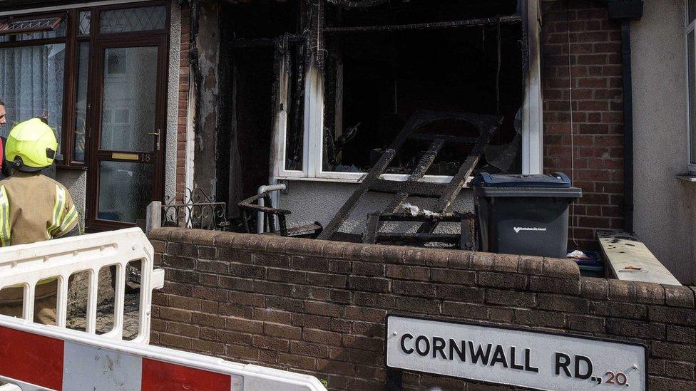 Firefighters at the scene of a cordoned-off house