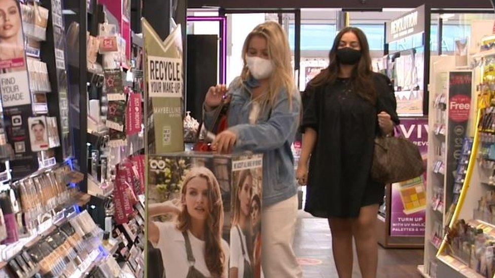 Customers using the recycling point at a Superdrug store