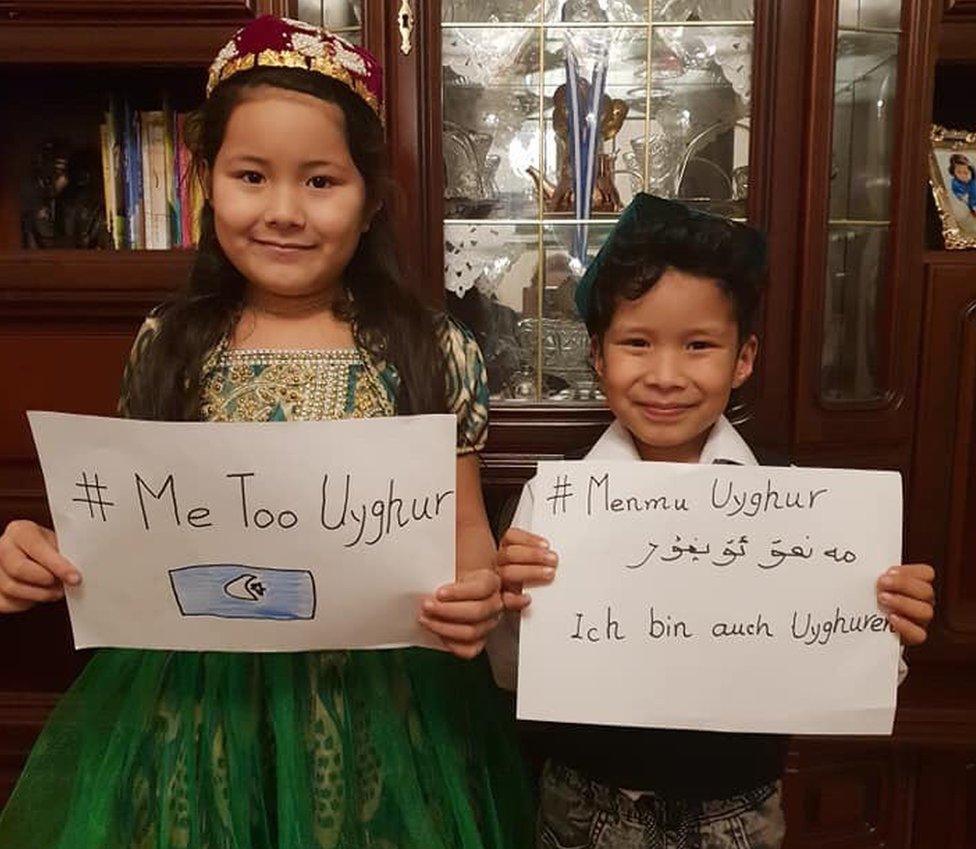 Two children holding up #MeTooUyghur posters