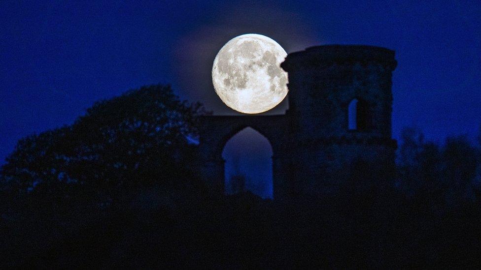 The moon sets behind Mow Cop in Staffordshire before the April super full moon on the 27th