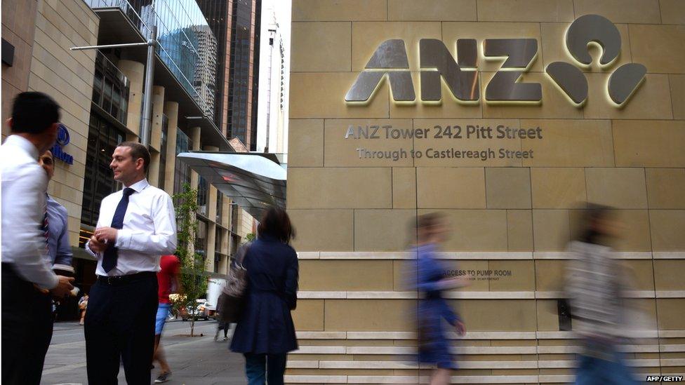 Pedestrians walk past the entrance to the Australia and New Zealand Banking Group (ANZ) building