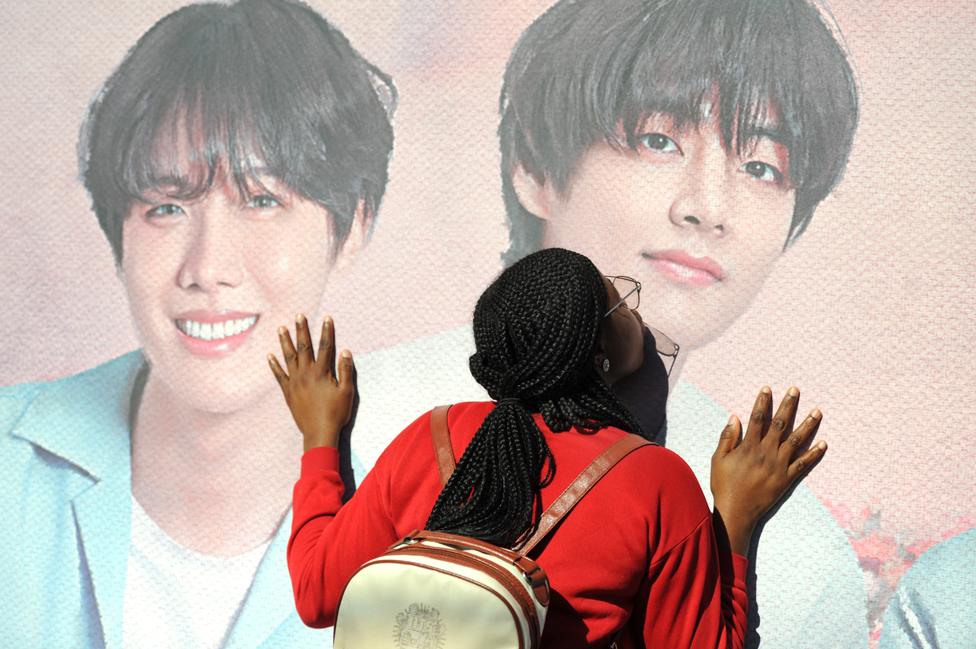 Fan kisses poster of BTS