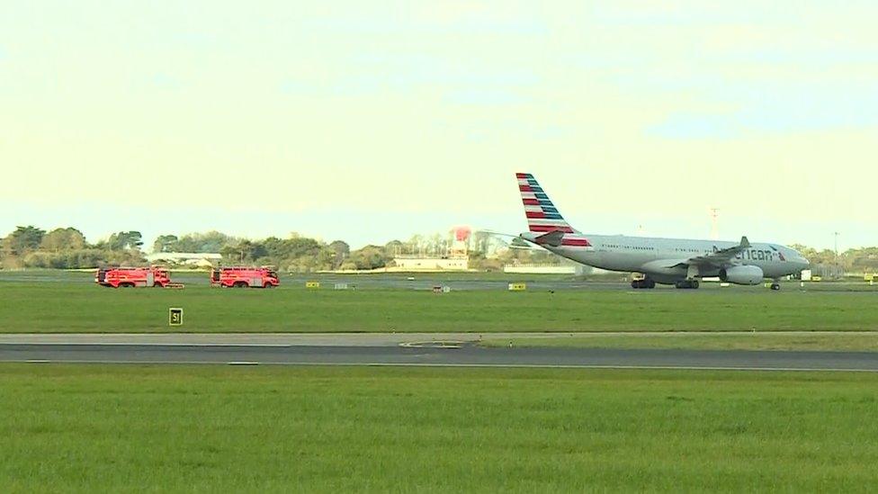 An American Airlines plane is followed by fire crews as it taxis across the runway at Dublin airport