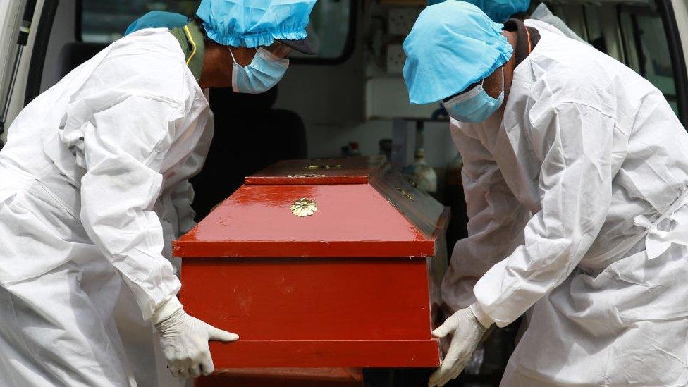 Sri Lankan municipal cemetery workers dressed protective suits carry a coffin of a Covid-19 virus victim for cremation at Colombo, Sri Lanka. 21 December 2020.