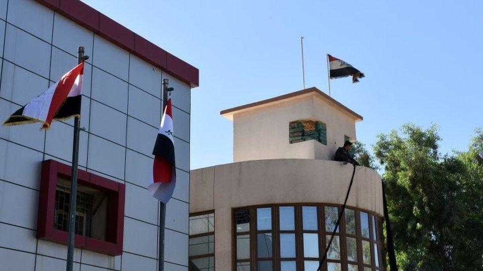 The Iraqi national flag swaying to the wind above the Kirkuk Governorate building in the multi-ethnic northern Iraqi city (17 October 2017)