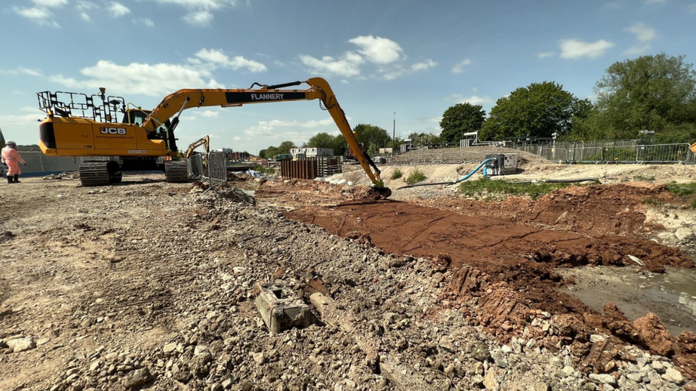 A large digger stretches the breadth of the new riverbed