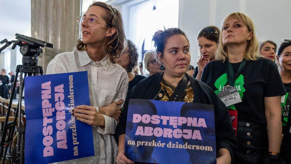 Pro-choice activists hold placards reading "abortion available" at a press conference in the Polish Parliament on the day Polish MPs will start a long awaited debate on liberalising abortion laws, in Warsaw, Poland on April 11, 2024.