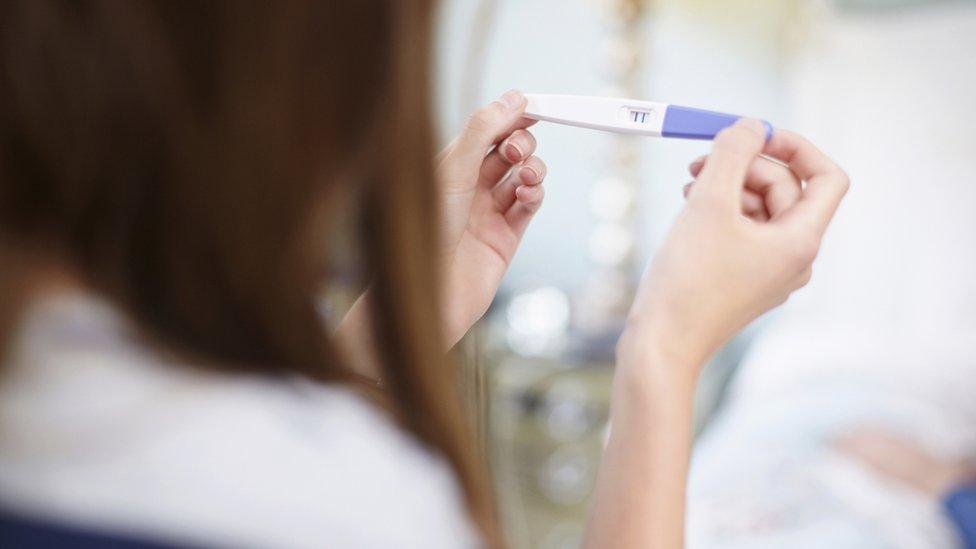 Woman holding pregnancy test