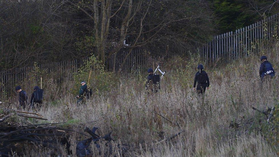 Police searching the area near a security alert in Strabane