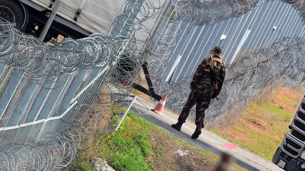 A Hungarian soldier patrols at the Hungarian border fence at the Tompa border station transit zone on 6 April 2017