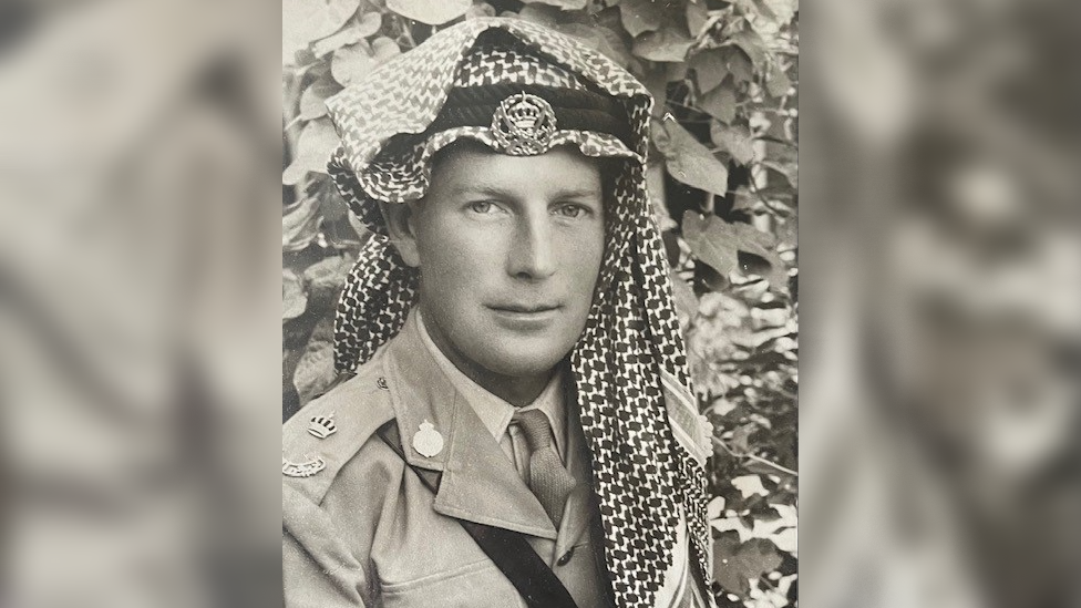 A young John Hamilton during service wearing his military uniform and a desert warfare head covering