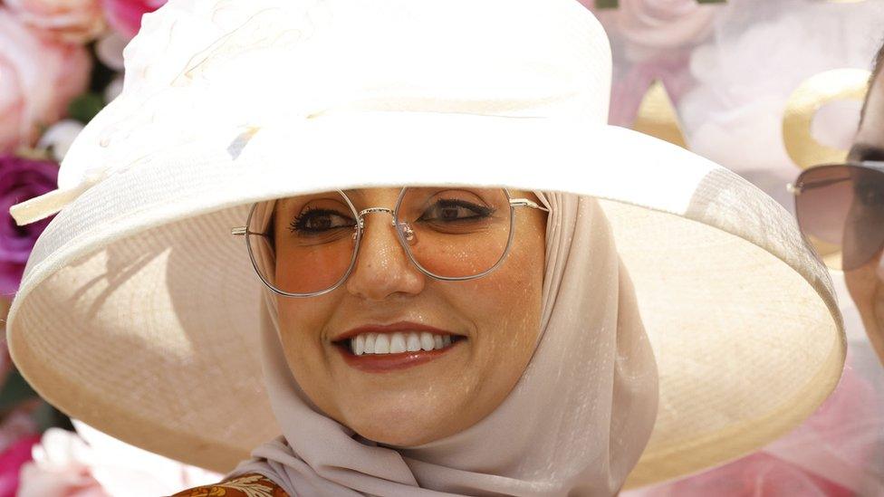 A woman in sunglasses and a white hat